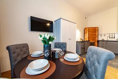 a dining room table with chairs and a tableasteryasteryasteryasteryasteryasteryastery at MILU Apartments Kurkowa in Kraków