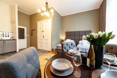 a living room with a couch and a table with wine glasses at MILU Apartments Kurkowa in Kraków