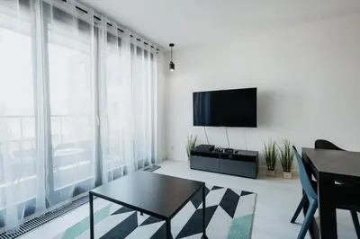 a living room with a flat screen tv and a table at Arcade Old Town with Free Parking in Kraków