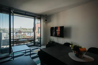 a living room with a table and a large window at Arcade Old Town with Free Parking in Kraków