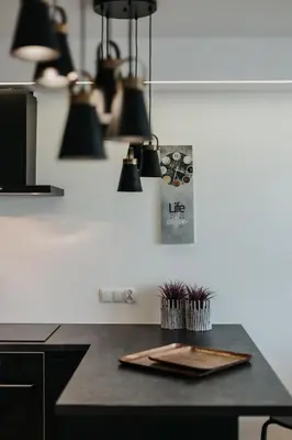 a kitchen with a counter with lights on the wall at Arcade Old Town with Free Parking in Kraków