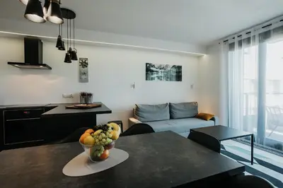 a living room with a table with a bowl of fruit on it at Arcade Old Town with Free Parking in Kraków
