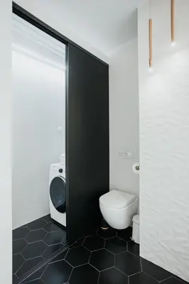 a bathroom with a white toilet and a black door at Arcade Old Town with Free Parking in Kraków