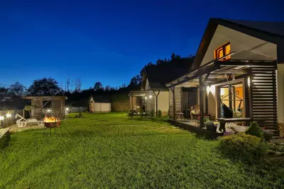 a patio with a table and a glass door at Domki i tyle in Rabka