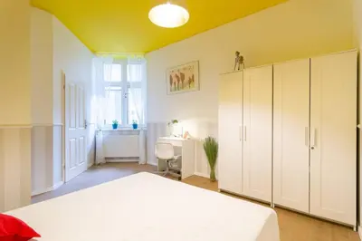 a bedroom with a white bed and a window at Apartament w sercu krakowskiego Kazimierza in Kraków
