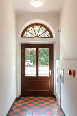 a hallway with a door and a tile floor at Apartament w sercu krakowskiego Kazimierza in Kraków