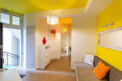 a living room with yellow walls and a couch at Apartament w sercu krakowskiego Kazimierza in Kraków
