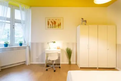 a bedroom with a bed and a desk and a window at Apartament w sercu krakowskiego Kazimierza in Kraków
