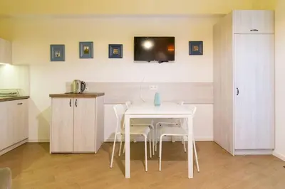 a kitchen with a white table and white chairs at Apartament w sercu krakowskiego Kazimierza in Kraków