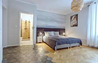 a bedroom with a bed and a bathroom with a shower at Kana - Stylish Apartment in Kraków Pomorska - Close, WiFi, Smart TV in Kraków