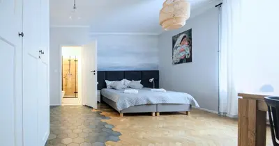 a bedroom with a bed and a blue wall at Kana - Stylish Apartment in Kraków Pomorska - Close, WiFi, Smart TV in Kraków