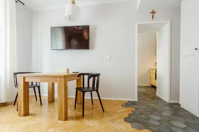a dining room with a wooden table and chairs at Kana - Stylish Apartment in Kraków Pomorska - Close, WiFi, Smart TV in Kraków