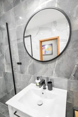 a bathroom with a white sink and a mirror at Apartament Komfort 17 in Zator
