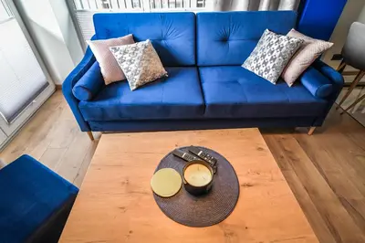 a blue couch with pillows and a table in a living room at Apartament Komfort 17 in Zator