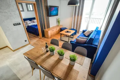 a living room with a table and a blue couch at Apartament Komfort 17 in Zator
