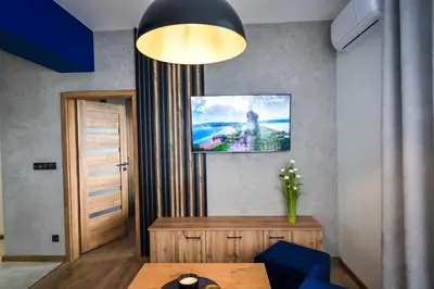 a room with a table and a tv on the wall at Apartament Komfort 17 in Zator