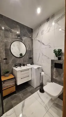a bathroom with a toilet and a sink and a mirror at Apartament Komfort 17 in Zator