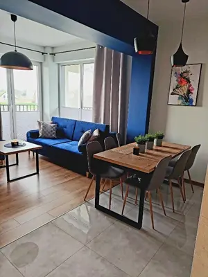 a living room with a blue couch and a table at Apartament Komfort 17 in Zator