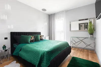 a bedroom with a bed with a green comforter at Victoria Apartment in Kraków