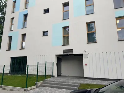 a white building with a garage in front of it at Victoria Apartment in Kraków