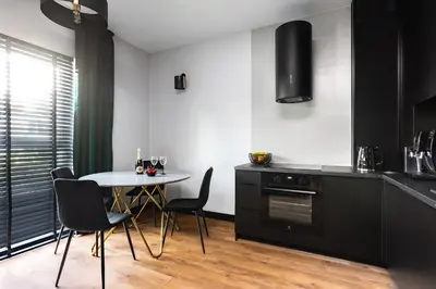 a kitchen with a table and chairs in a room at Victoria Apartment in Kraków