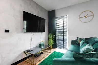a living room with a green couch and a table at Victoria Apartment in Kraków