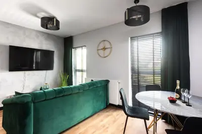 a living room with a green couch and a table at Victoria Apartment in Kraków