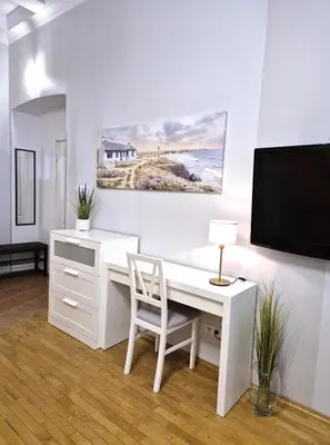 a white desk with a chair and a tv at Ariadna - Pantheon Apartments in Kraków
