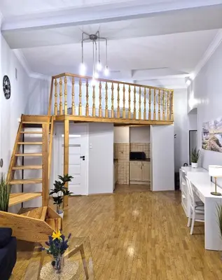 a loft apartment with a staircase and a living room at Ariadna - Pantheon Apartments in Kraków