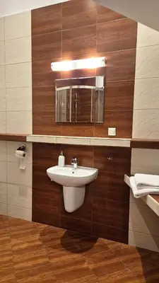 a bathroom with a sink and a mirror at Ariadna - Pantheon Apartments in Kraków