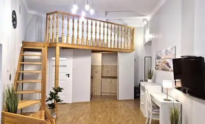 a loft apartment with a staircase and a living room at Ariadna - Pantheon Apartments in Kraków