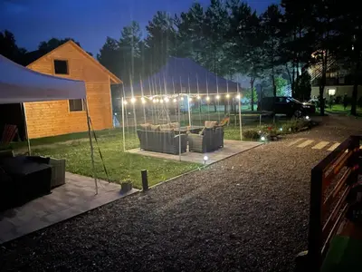 a tent with couches in a yard at night at Noclegi u Eli Zator Energylandia in Zator