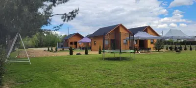 a group of lodges with a ping pong table in a yard at Noclegi u Eli Zator Energylandia in Zator