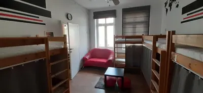 a room with four bunk beds and a red chair at Kraków Chilli Hostel in Kraków