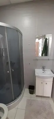 a bathroom with a shower and a sink and a mirror at Kraków Chilli Hostel in Kraków