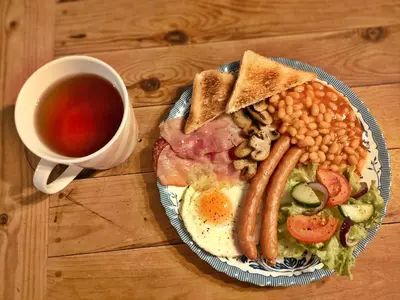 a plate of breakfast food with eggs beans and a cup of tea at RESETówka nr 2 - domek rodzinny na odludziu in Jaszczurowa