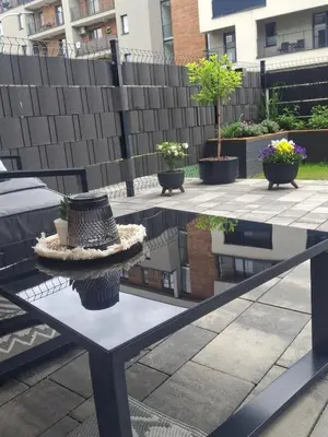 a table on a patio with potted plants on it at Apartament LUX in Zator