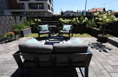 a couch and chairs sitting on a patio at Apartament LUX in Zator