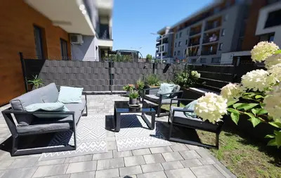 a patio with chairs and tables and a fence at Apartament LUX in Zator