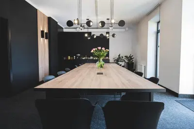 a conference room with a wooden table with flowers on it at VANTA Business Center in Skawina