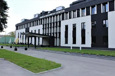 a large white building with a sign on it at VANTA Business Center in Skawina