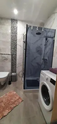 a bathroom with a shower and a washing machine at Apartament 59 JUSTI in Zator