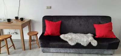 a black couch with two red pillows next to a table at Apartament 59 JUSTI in Zator