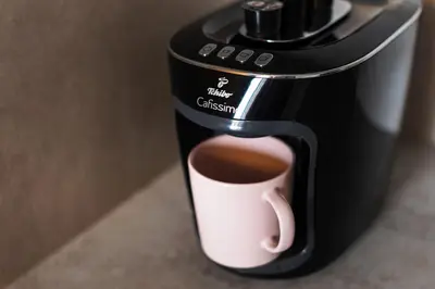 a coffee maker with a cup of coffee at City of the Kings-Alice Apartment in Kraków