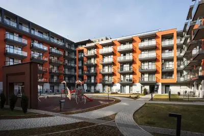 an apartment building with a playground in front of it at City of the Kings-Alice Apartment in Kraków