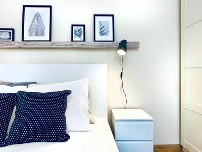 a bedroom with a white bed with a black lamp at Cozy Apartment in the heart of Cracow, Jewish District in Kraków