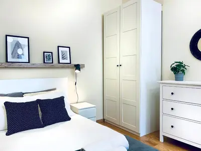 a bedroom with a white bed and a white cabinet at Cozy Apartment in the heart of Cracow, Jewish District in Kraków