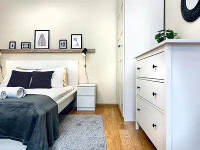 a bedroom with a white bed and a dresser at Cozy Apartment in the heart of Cracow, Jewish District in Kraków