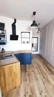 a kitchen with blue cabinets and a wooden floor at Aleja Krasińskiego 5 by Homeprime in Kraków