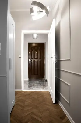 an empty hallway with a door and wooden floors at Aleja Krasińskiego 5 by Homeprime in Kraków